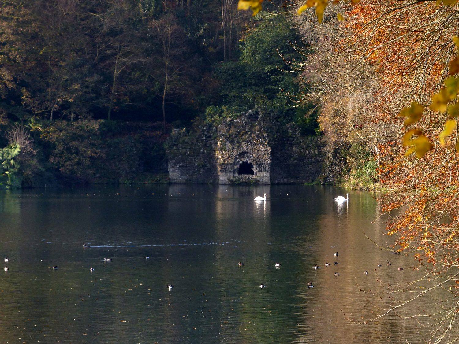 Stourhead garden, the Grotto entrance across the lake in autumn