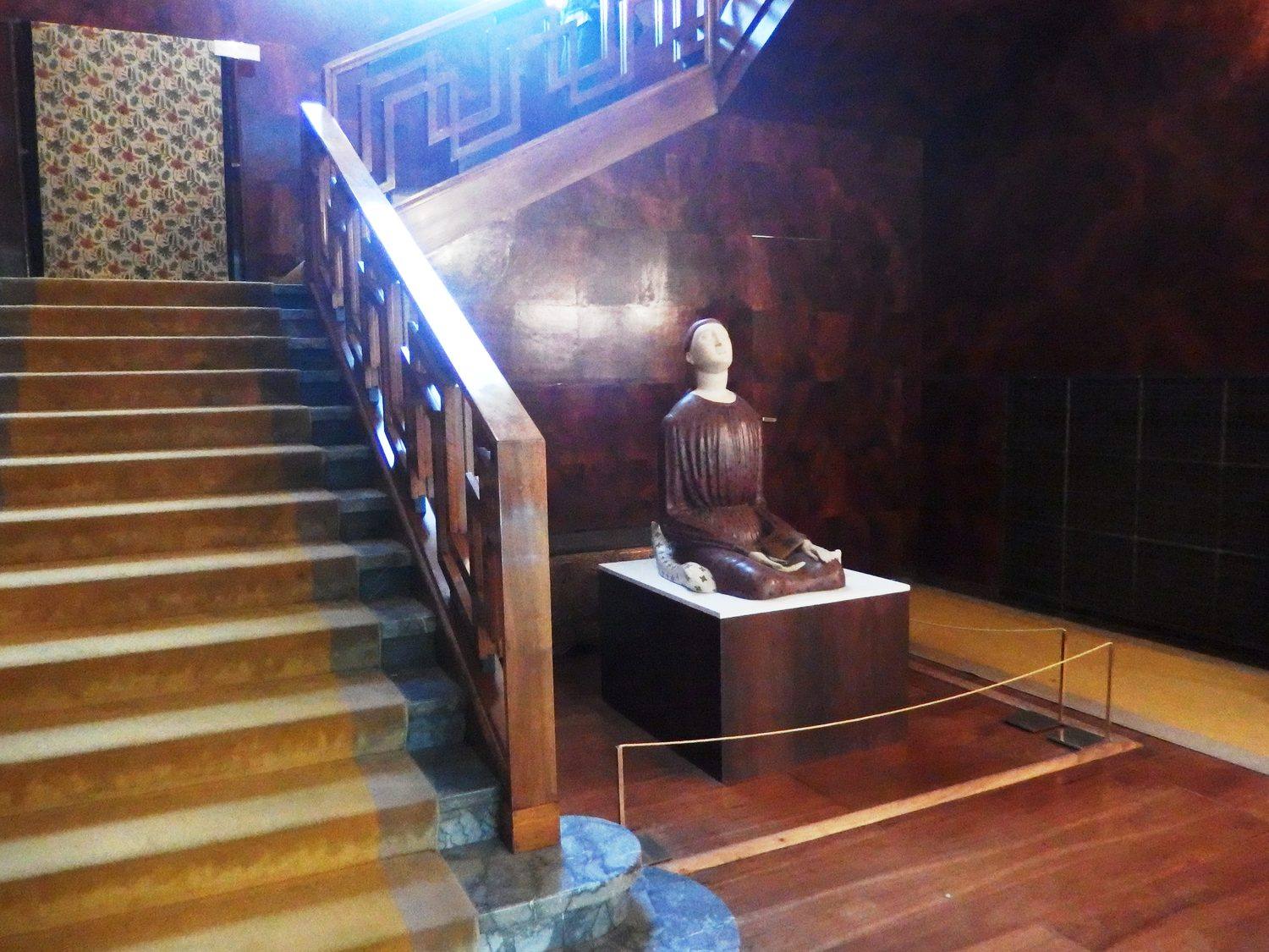 The entrance hall staircase with its double Greek key wooden balustrade and dark wood panelling