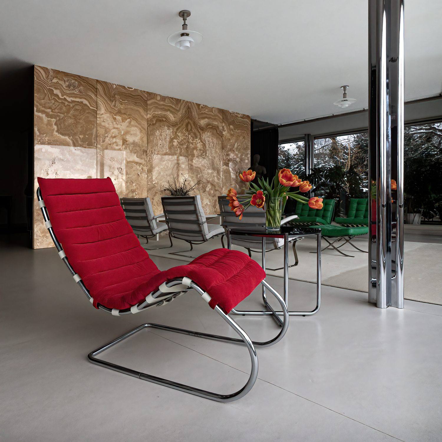 The onyx partition in the main living room, with a red velvet reclining chair, chrome cruciform column and Barcelona chairs