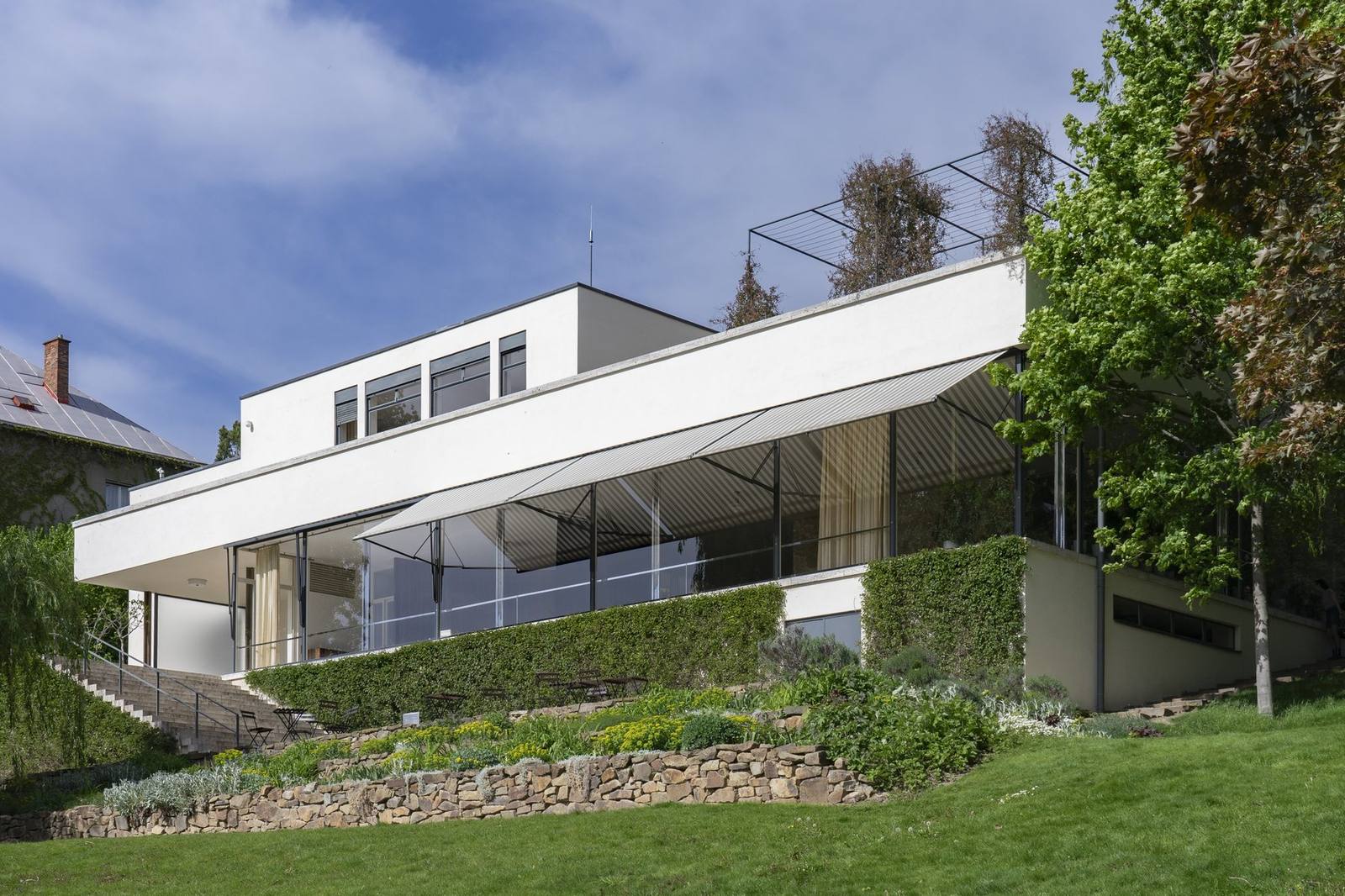 Villa Tugendhat, Brno, the glass garden facade with the white bedroom volume above and the terraced garden below
